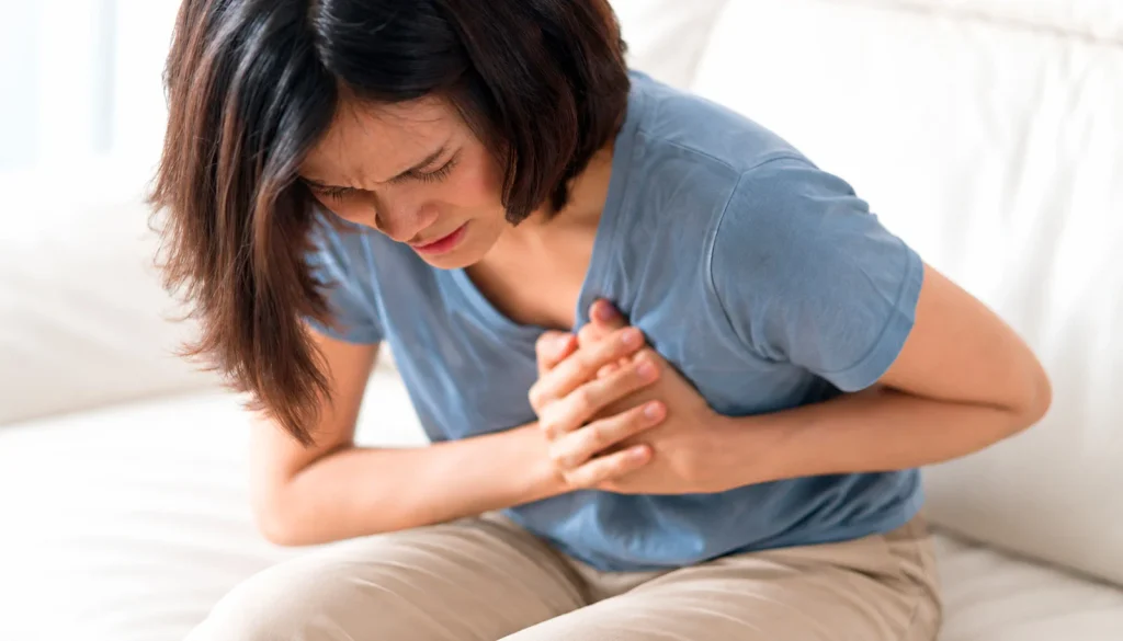 Mujer con dolor en el pecho, posible síntoma de infarto